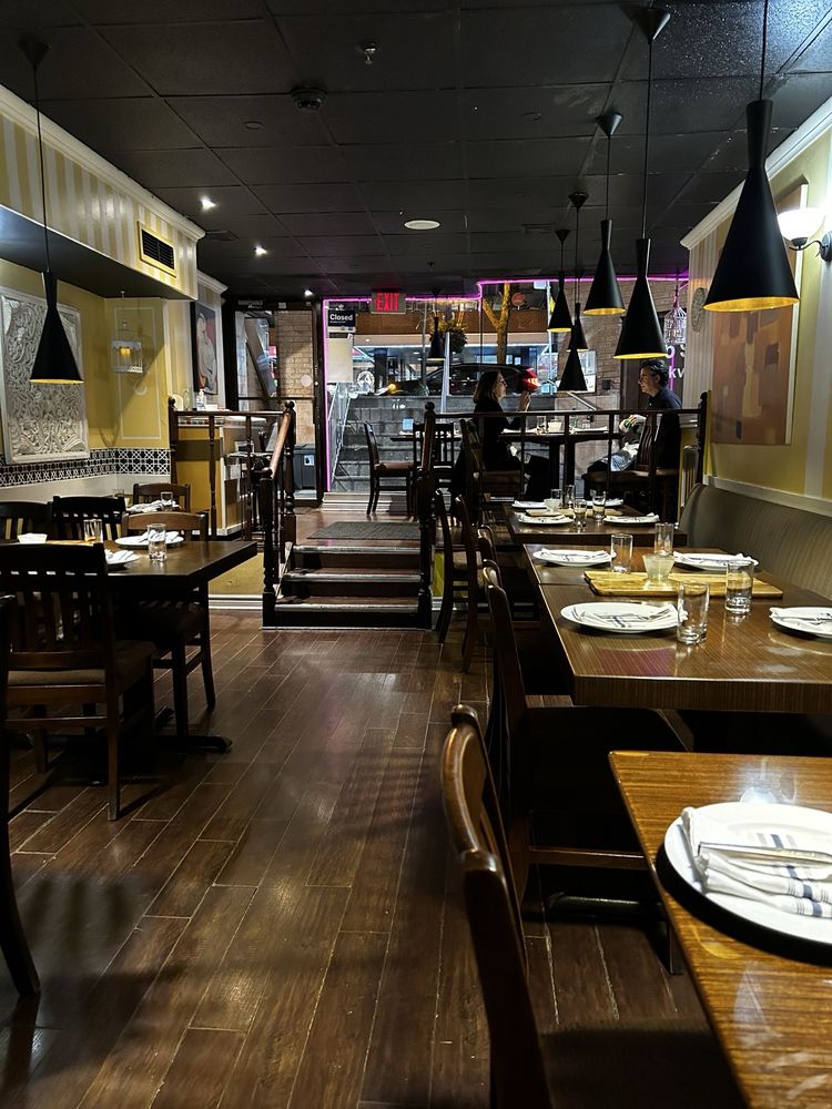 The UTSAV dining room in Yorkville, with set tables and pendant lights